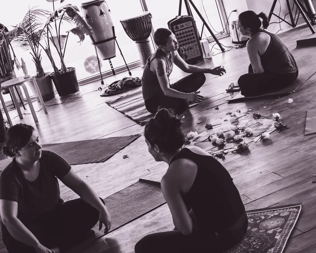Women in circle, sharing and listening with rose petals at their feet