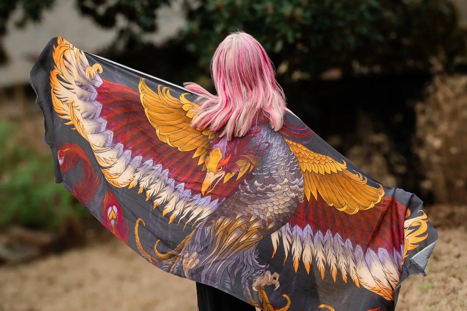 Erin wrapped in a phoenix scarf, pink hair, wings spread wide — rising